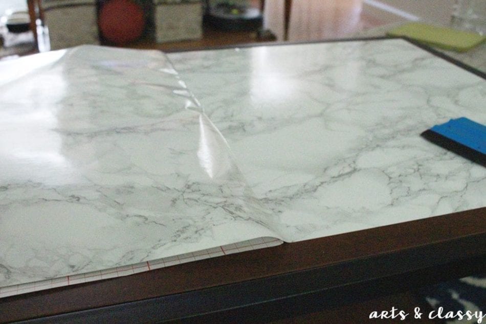 DIY Faux Marble Coffee Table Makeover applying the marble contact paper