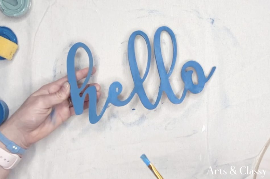 Painting the hello wood cutout was the next step for my DIY farmhouse wall decor! I decided to paint it the same color as the craft hoop trim because it would really add dimension and cohesiveness to the overall sign. 