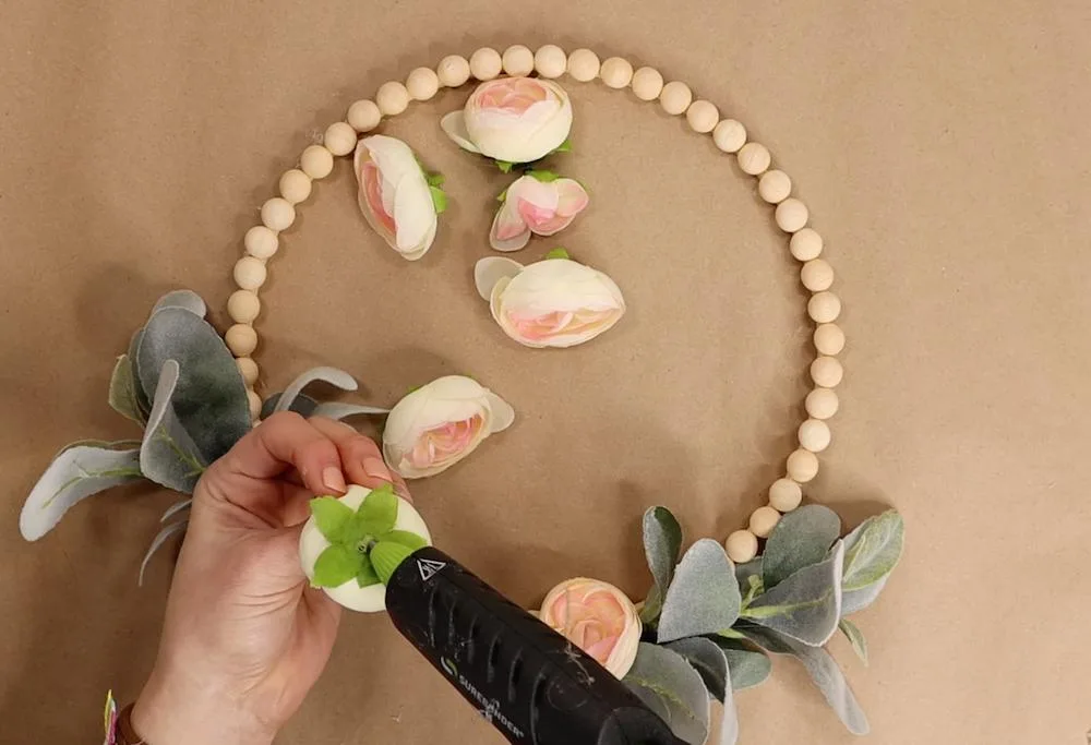 I chose to use ranunculus blooms for this DIY spring wreath project. I was tempted to use eucalyptus as well but I was trying my best to make this a very budget-friendly diy spring wreath idea. I hot glue the blooms covering the lamb's ear and the wood hoop wreath form. 