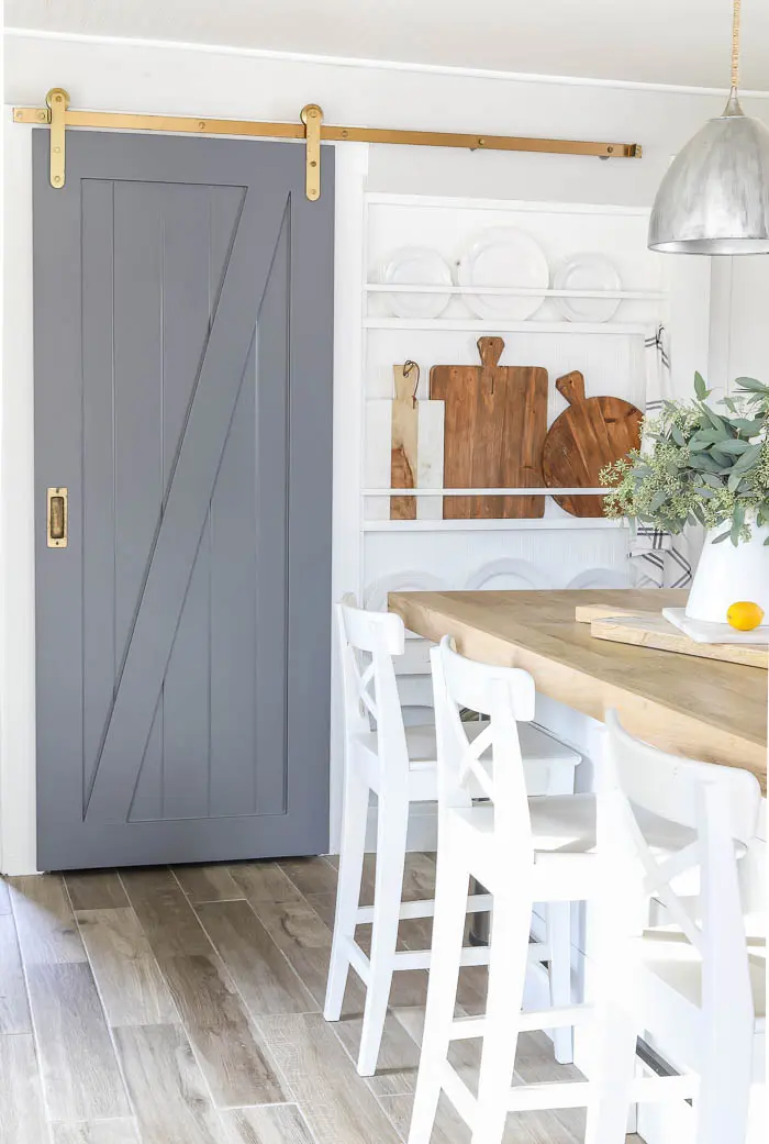 Learn valuable tips for decorating your farmhouse kitchen, from coordinating colors to incorporating open shelving and more. No farmhouse kitchen is complete without a barn door. 
